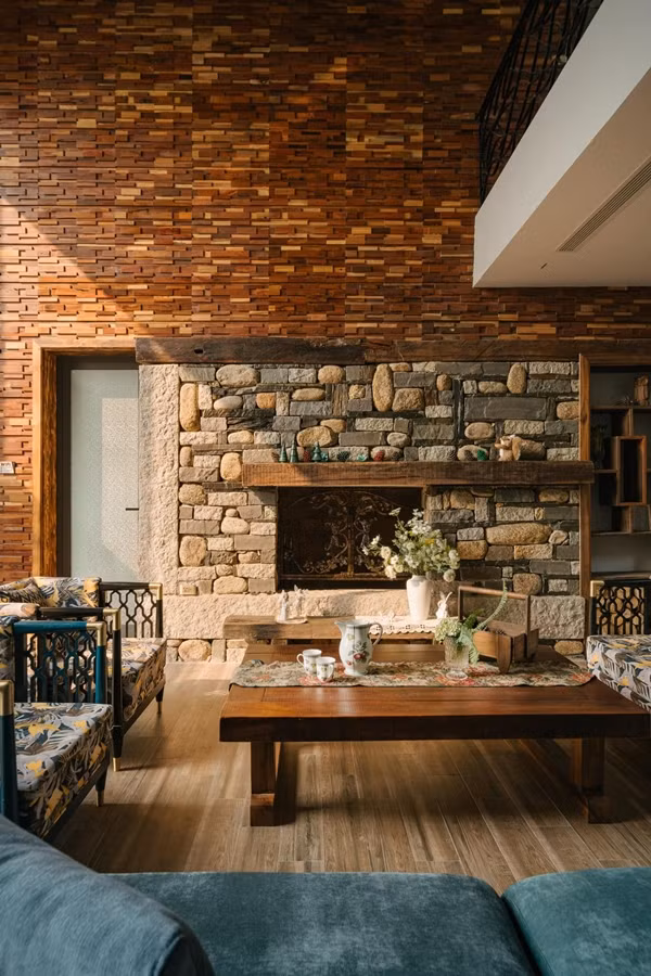 Điểm nhấn trong phòng khách là lò sưởi ốp đá tự nhiên, tường ốp gỗ và decor theo phong cách vintage châu Âu. Ảnh: Baophunuthudo