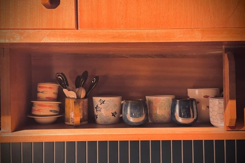 Góc bếp mộc mạc với tủ gỗ và bát đĩa xinh xắn. Ảnh: FB Bùi Đại Nghĩa