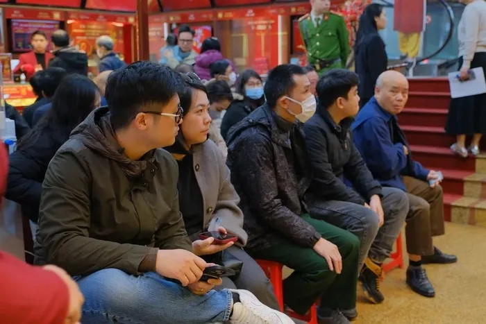 Hàng dài người kiên nhẫn xếp hàng chờ tới lượt giao dịch. (Ảnh: Trung Kiên/Vietnam+)