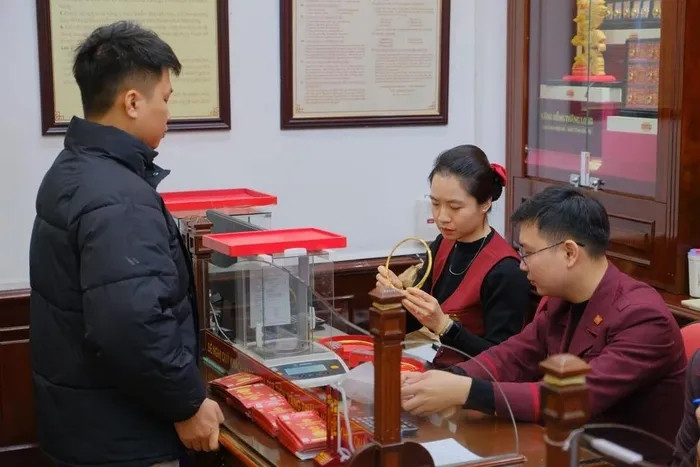 Giao dịch vàng trong ngày sôi động, từng chỉ vàng đều được kiểm tra kỹ lưỡng trước khi trao tay. (Ảnh: Trung Kiên/Vietnam+)
