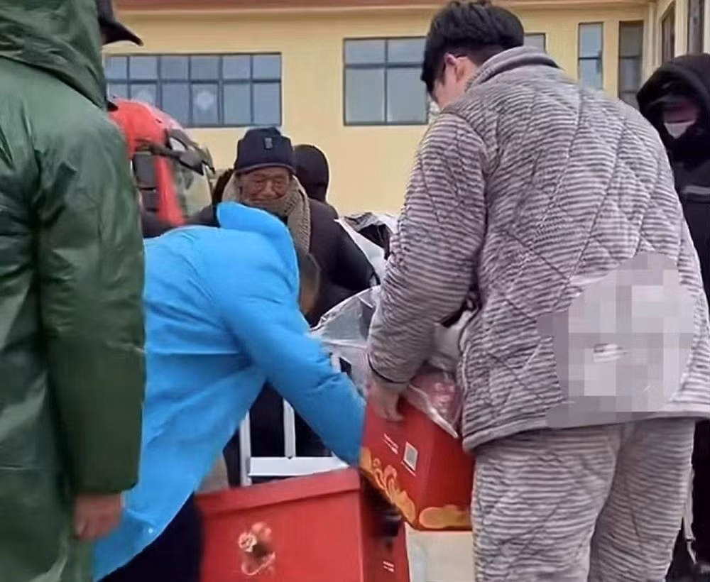 Toàn bộ số quà tặng được 40 ô tô chở về làng. Mọi người đều phấn khởi, chờ nhận tấm lòng của nam doanh nhân thành đạt. Ảnh: Paper