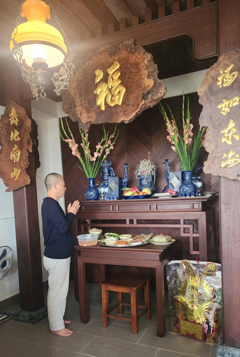 Không gian thờ cúng trang nghiêm với bàn thờ bằng gỗ nâu chạm khắc tinh xảo. Ảnh: FB Trần Bình Trọng