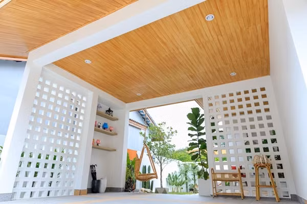 Phần hiên bên ngoài nhà được bố trí làm nơi để xe. Gia chủ thiết kế kệ treo tường cung cấp thêm không gian lưu trữ. Ảnh: Thesmartlocal