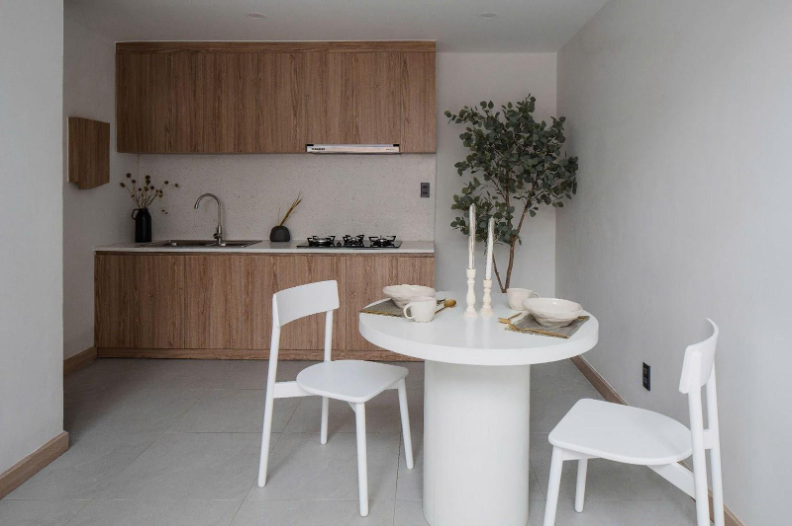 Gỗ sồi mang lại sự ấm áp, bàn bếp đá mài trắng tạo điểm nhấn hiện đại, trong khi tủ âm tường và cửa trượt giúp tiết kiệm diện tích. Ảnh: Quang Trần