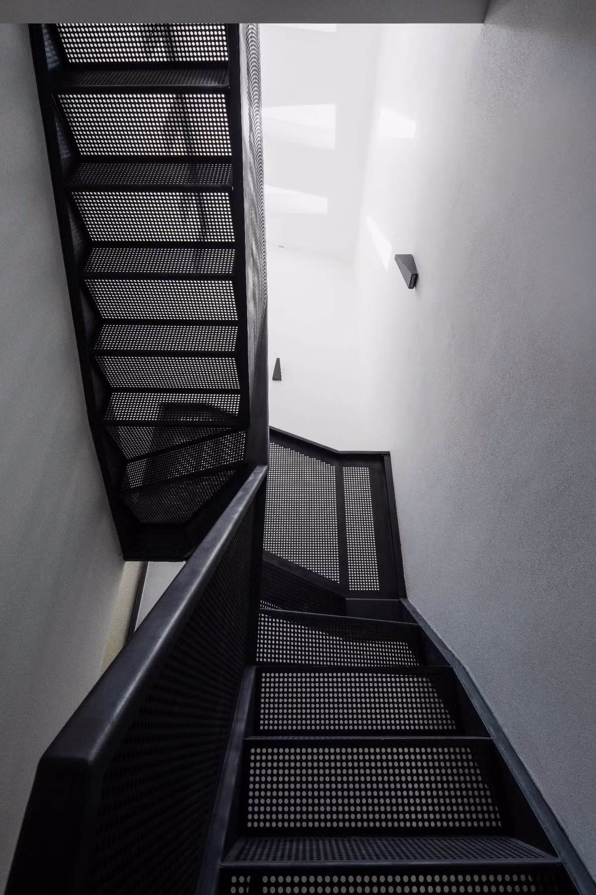 Cầu thang thiết kế với cấu trúc lưới, lọc ánh sáng khắp căn nhà, tăng cường tính liên tục về mặt thị giác và cảm giác cởi mở. Ảnh: Quang Trần