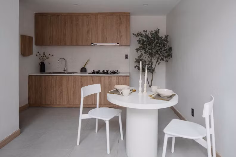 Gỗ sồi mang lại sự ấm áp, bàn bếp đá mài trắng tạo điểm nhấn hiện đại, trong khi tủ âm tường và cửa trượt giúp tiết kiệm diện tích. Ảnh: Quang Trần