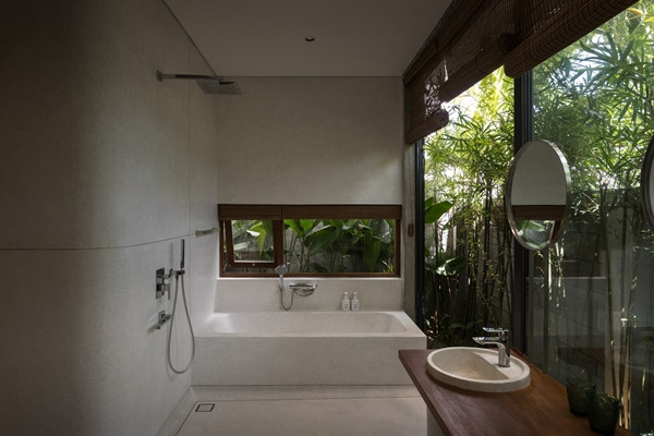 Phòng tắm mang phong cách thư giãn, hòa cùng thiên nhiên nhờ các cửa kính lớn và cây xanh xung quanh. Ảnh: SuKha_Studio