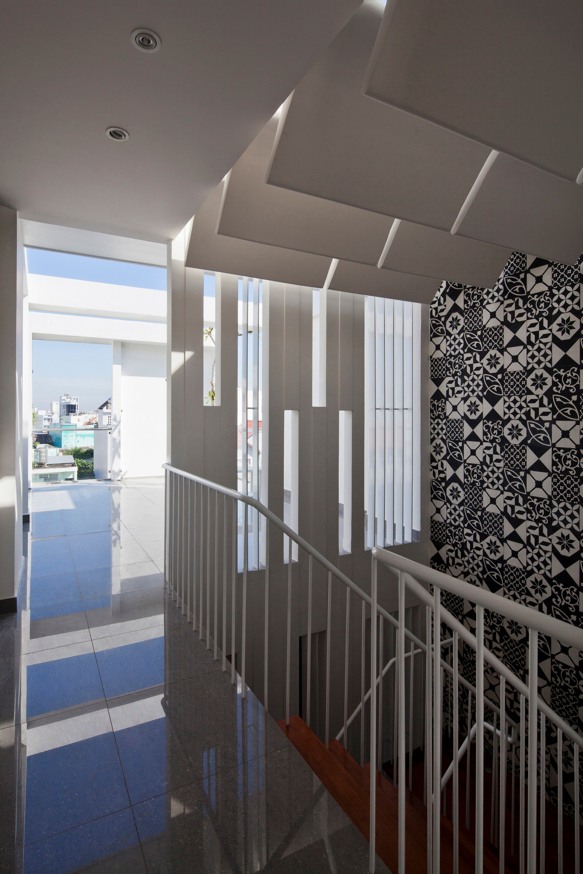 Cùng với đó, ánh nắng lấy từ trên xuống ở giếng trời ngay giữa nhà, được lọc bởi các tấm lam thạch cao ngang dưới mái kính. Ảnh: Hiroyuki Oki