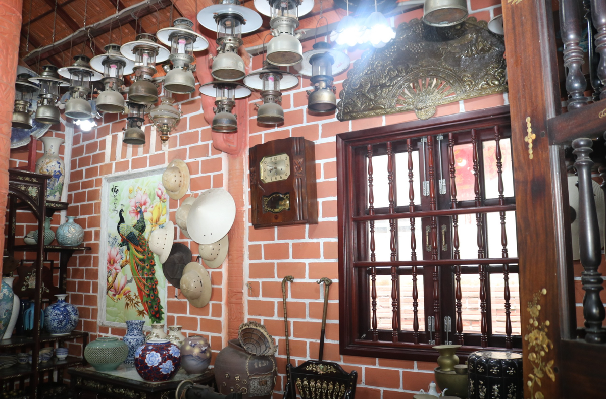 Bên trong "biệt phủ" gốm đỏ, ông Buôi trang trí rất nhiều đổ cổ. Ảnh: Người lao động