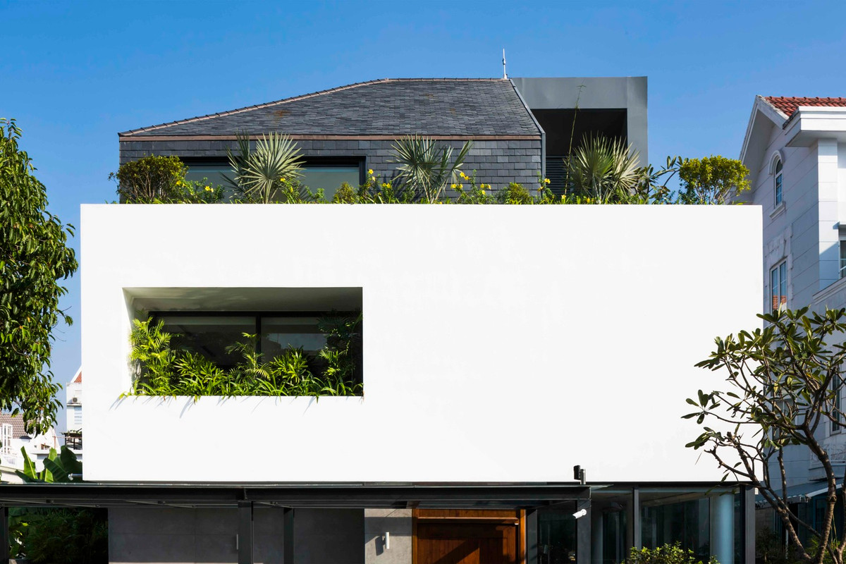 Tầng hai là khối thứ ba tách biệt lõm vào, nằm trên khối lập phương màu trắng. Mái dốc và tường được lợp bằng ngói đá phiến. Ảnh: Hiroyuki Oki