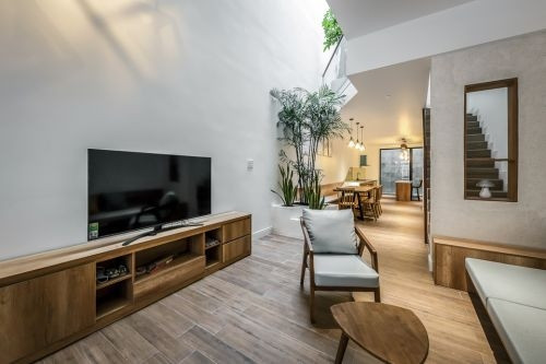 Nhà gồm 3 tầng được thiết kế với phong cách hiện đại đan xen nét truyền thống quen thuộc. Tầng 1 là không gian của khu vực để xe, phòng khách, phòng bếp - ăn và sân sau. Ảnh: Bùi Minh Quốc