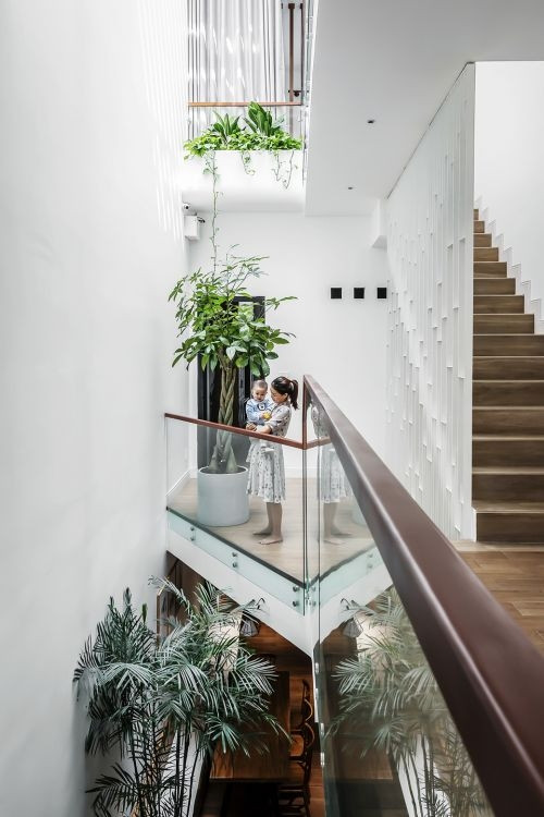 Để ánh sáng tự nhiên len lỏi khắp nơi, kiến trúc sư thiết kế khoảng thông tầng qua khe hẹp nằm dài. Nhờ đó, phía trước và phía sau nhà trong hẻm đều được đối lưu không khí một cách toàn diện. Ảnh: Bùi Minh Quốc