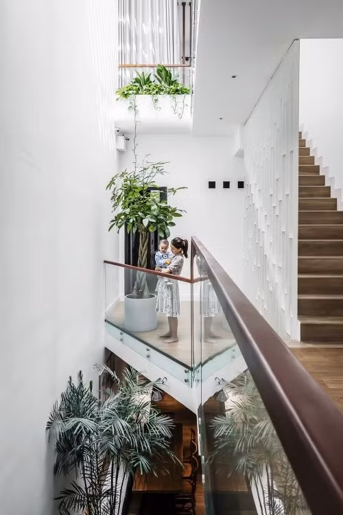 Để ánh sáng tự nhiên len lỏi khắp nơi, kiến trúc sư thiết kế khoảng thông tầng qua khe hẹp nằm dài. Nhờ đó, phía trước và phía sau nhà trong hẻm đều được đối lưu không khí một cách toàn diện. Ảnh: Bùi Minh Quốc