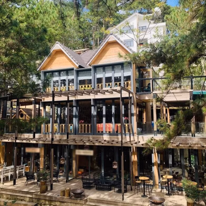 Hai căn biệt thự của Phan Như Thảo ở Đà Lạt thiết kế mái dốc và khung kính lớn, bao quanh là cây xanh và hoa rực rỡ. Ảnh: FB Phan Như Thảo
