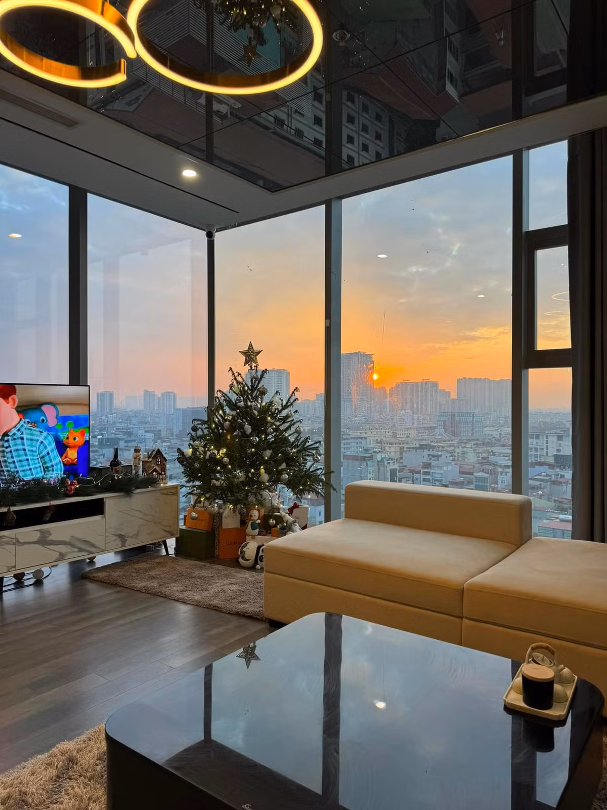 Điểm nhấn của căn hộ nằm ở phòng khách với hai mặt lắp kính từ sàn đến trần, giúp mở rộng tầm nhìn ra khung cảnh thành phố. Ảnh: FB Ngô Tố Uyên