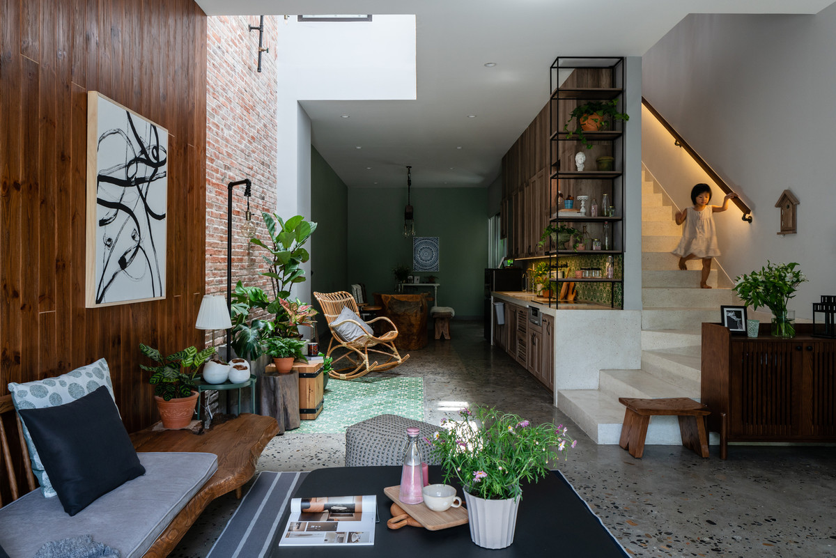 Phòng khách rộng rãi với nội thất bằng gỗ tự nhiên, hòa hợp với năng lượng xanh của những cây xanh nhỏ do từng thành viên trong gia đình trồng. Ảnh: QuangDam
