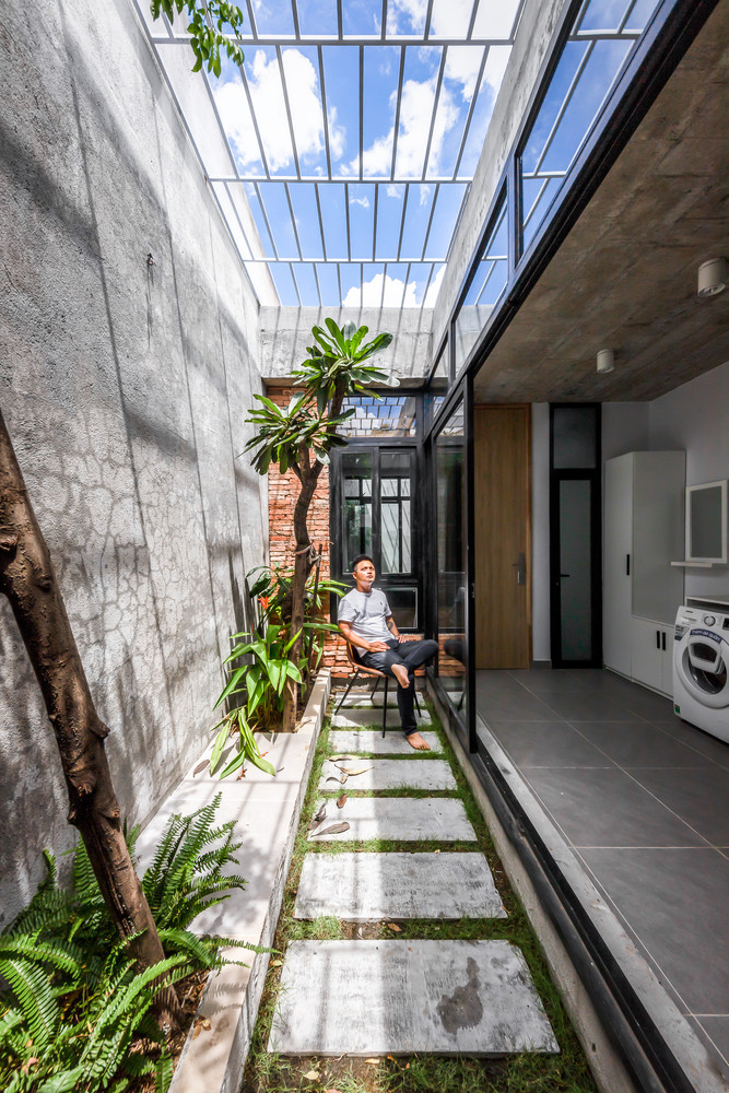 Sân vườn giữa nhà đưa ánh sáng tự nhiên khắp bên trong. Ảnh: Minq Bui