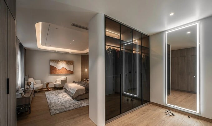 Phòng ngủ master có vách ngăn là tủ đồ vách kính đen, đảm bảo sự riêng tư. Ảnh chụp màn hình