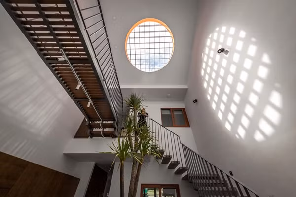 Giếng trời hình tròn, viền cam là điểm thú vụ trong nhà, giúp lấy ánh sáng tự nhiên toàn bộ trung tâm ngôi nhà. Ảnh: Architizer