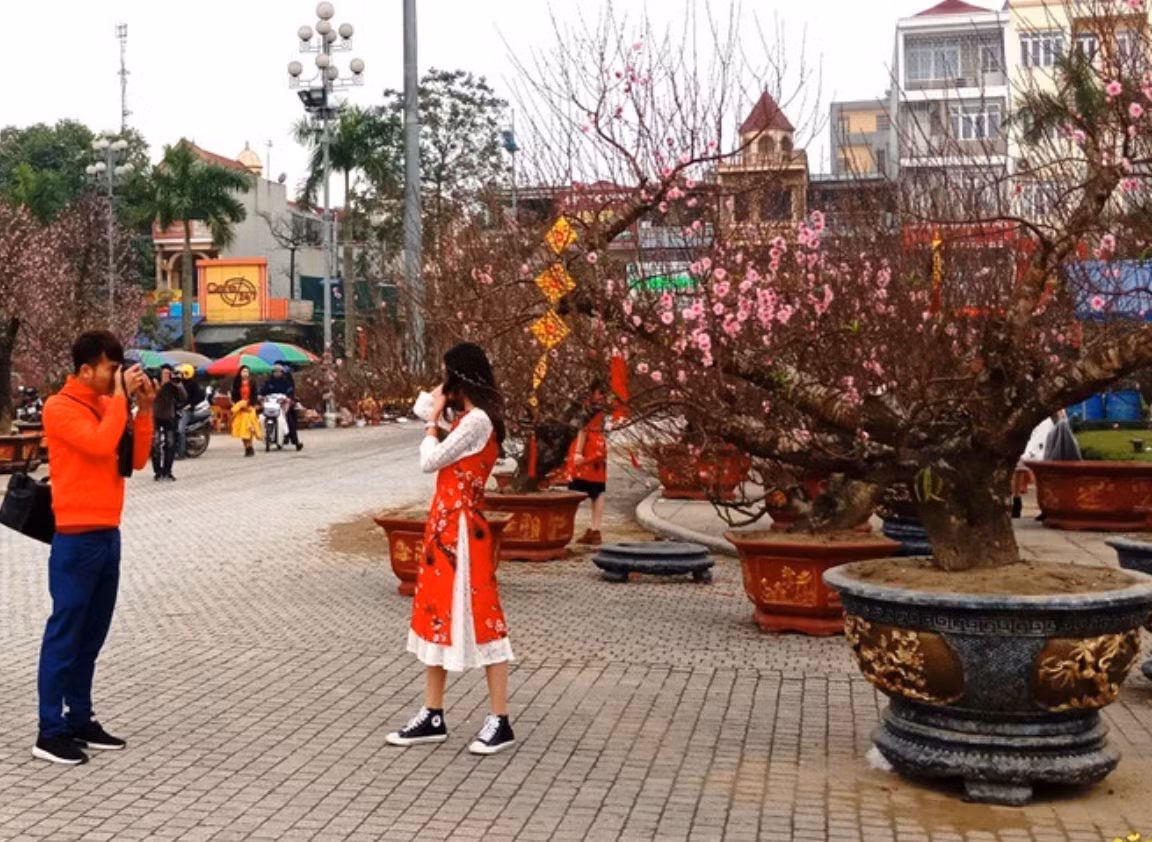 Xu hướng chụp ảnh cùng hoa Tết, đào Tết, các bộ ảnh Tết như chợ hoa, áo dài,... đang ngày càng tăng. Nhờ đó, nghề chụp ảnh dễ dàng kiếm thêm thu nhập vào thời điểm cuối năm. Ảnh: Internet