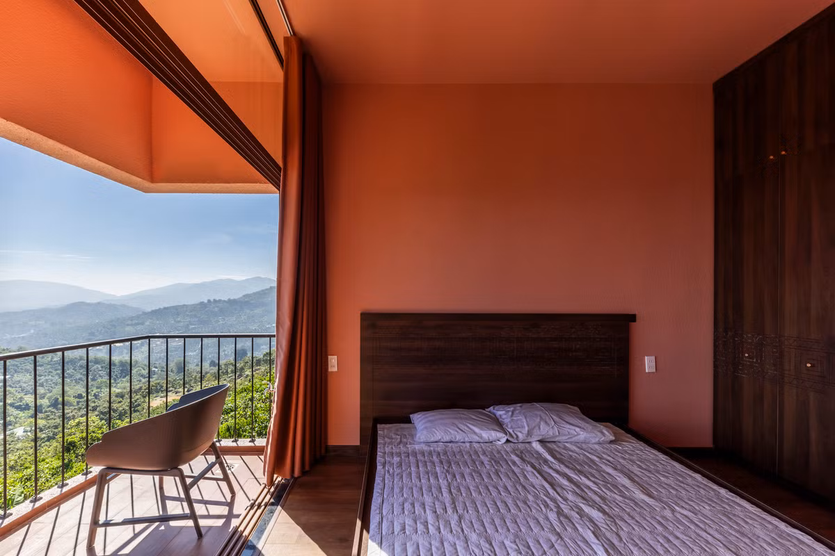 Phòng ngủ được bố trí ở vị trí cao hơn, nổi bật với gam màu hồng dịu dàng kết hợp cùng sắc trầm ấm của gỗ. Ảnh: Hiroyuki Oki