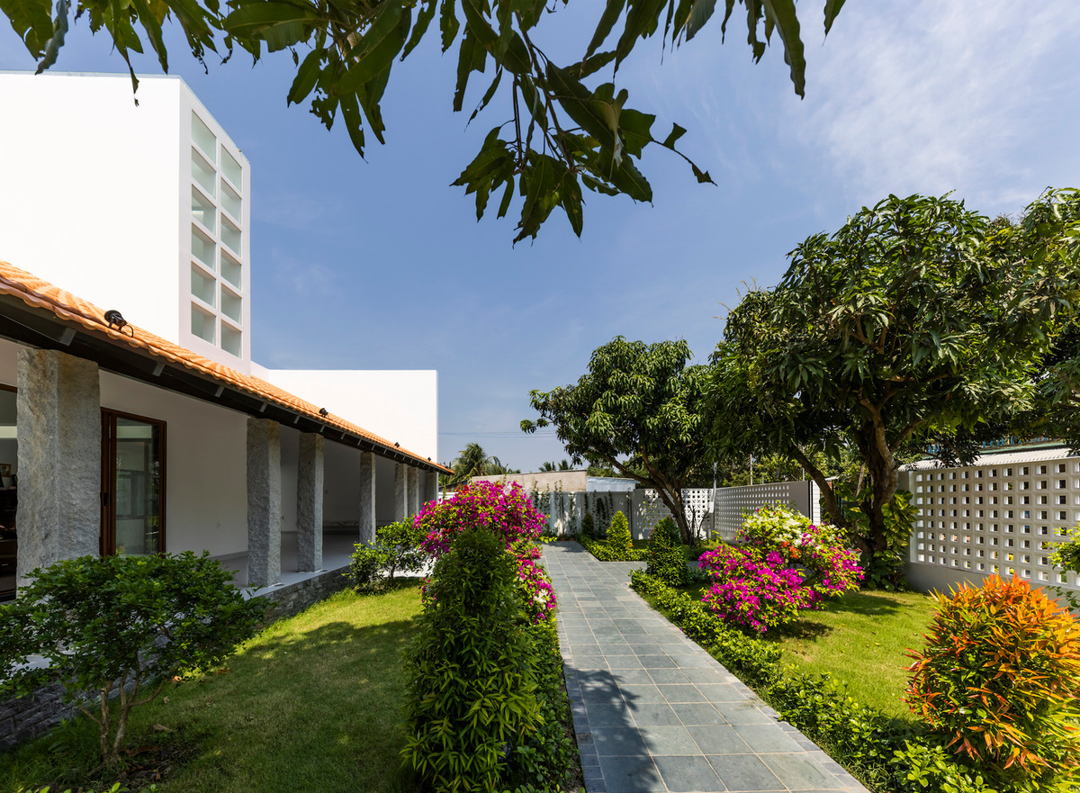 Sân trước nhà lát đá thủ công, bao quanh bởi nhiều cây xanh. Ảnh: Hiroyuki Oki