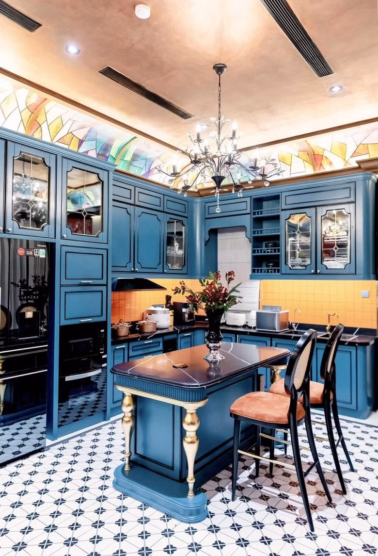 Phòng bếp phụ màu xanh chủ đạo, phối với gạch ốp tường màu cam tạo cảm giác ấm cúng. Ảnh: FBNV