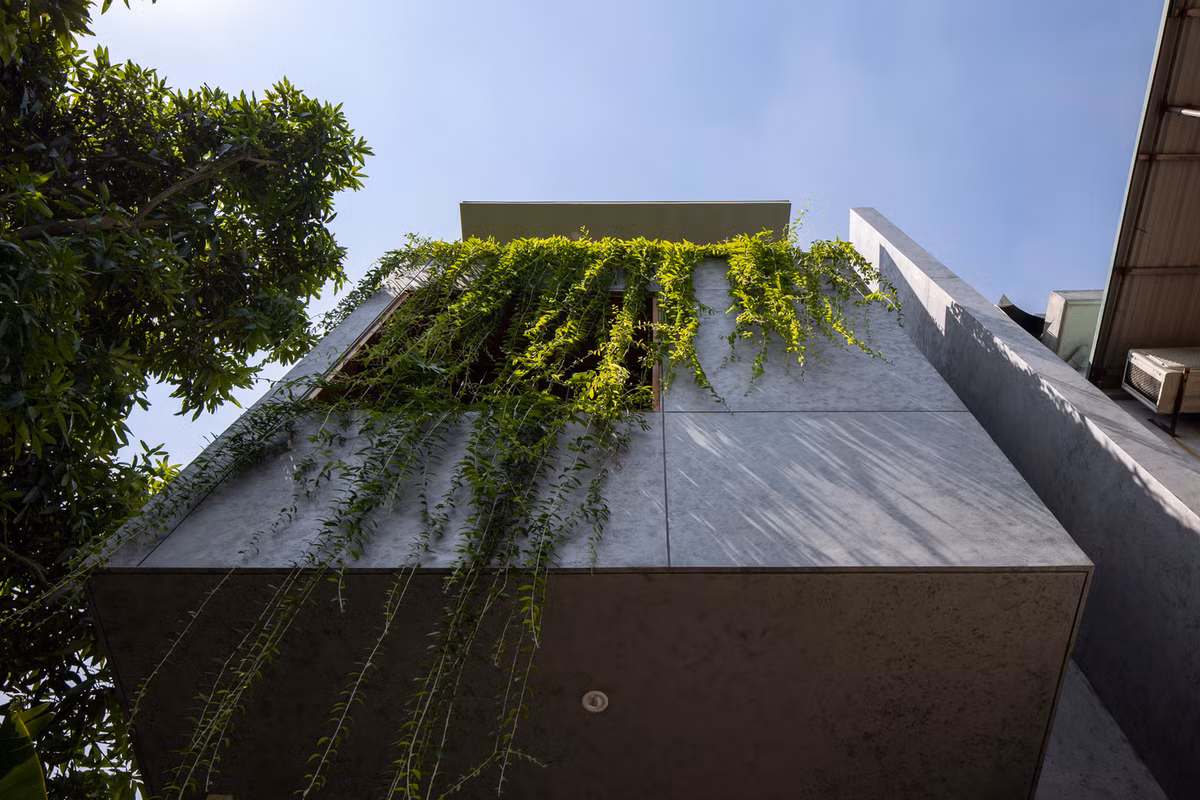 Nhìn từ bên ngoài, ngôi nhà trông khá kín đáo và riêng tư. Những mảng tường đặc kết hợp khoảng lùi cây xanh giúp hạn chế tác động của hướng nắng Tây Nam, đồng thời giảm thiểu tối đa lượng khói bụi và tiếng ồn từ bên ngoài. Ảnh: Hoàng Lê