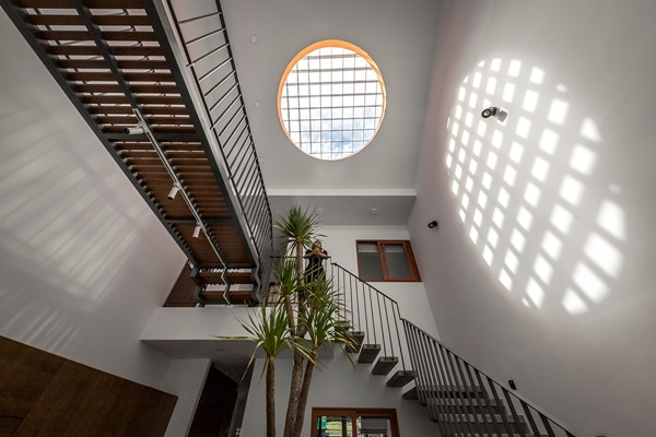 Chi tiết ấn tượng nhất trong nhà là giếng trời “skylight” hình tròn, viền màu cam ngay phía trên khu vực bếp ăn. Ảnh: SPACE+ Architecture