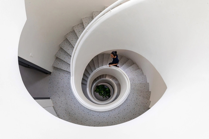 Cầu thang xoắn ốc ở chính giữa ngôi nhà giúp kết nối các tầng với nhau. Ảnh: ROOM+ Design &amp; Build