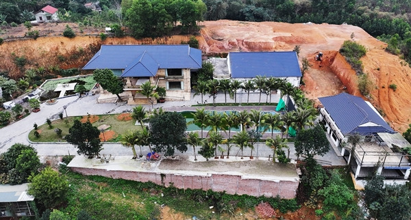 Khu biệt phủ gồm 3 khối nhà kiên cố, rộng lớn, có bể bơi và cây cảnh bao quanh. Phía sau biệt thự là quả đồi lớn được san gạt, múc bỏ đất nhằm lấy mặt bằng xây dựng. Ảnh: Vietnamnet