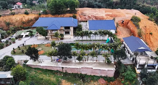 Khu biệt phủ gồm 3 khối nhà kiên cố, rộng lớn, có bể bơi và cây cảnh bao quanh. Phía sau biệt thự là quả đồi lớn được san gạt, múc bỏ đất nhằm lấy mặt bằng xây dựng. Ảnh: Vietnamnet