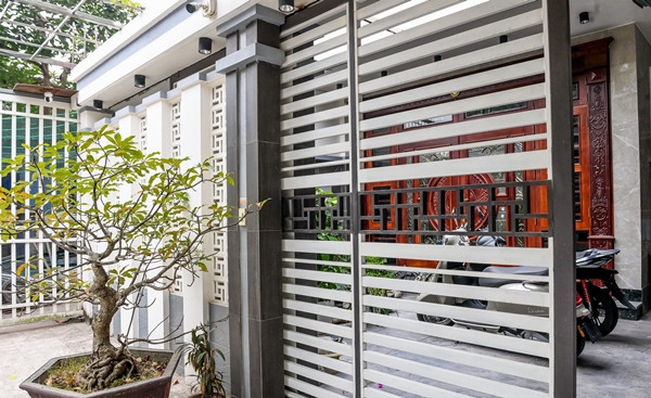 Nhà gồm 3 tầng, mỗi tầng đều có ban công riêng. Cổng chính thiết kế lam ngang, vừa thoáng đãng vừa tăng tính thẩm mỹ. Ảnh: Vietnamnet