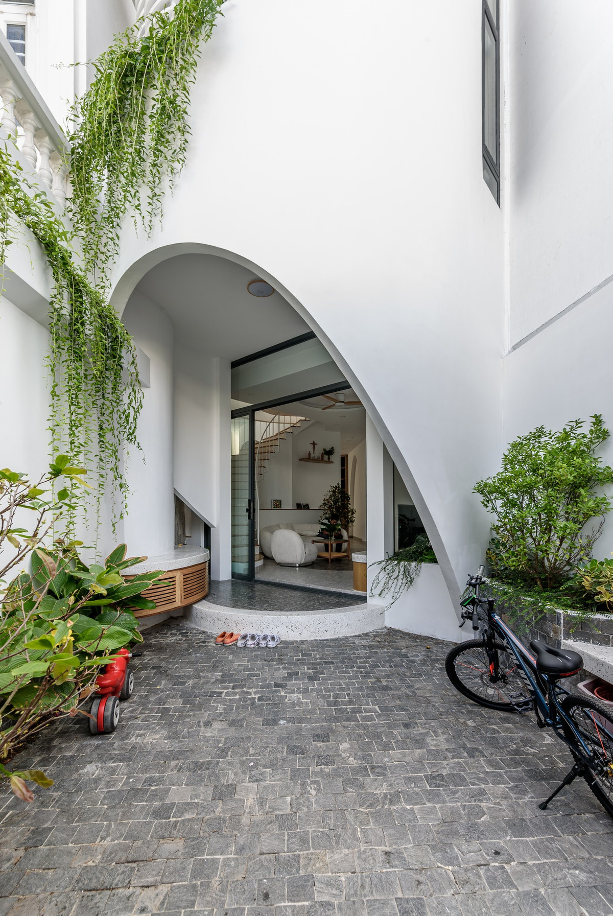 Tầng 1 có khoảng sân nhỏ, nhiều cây xanh và không gian sinh hoạt chung. Ảnh: Lonton Studio