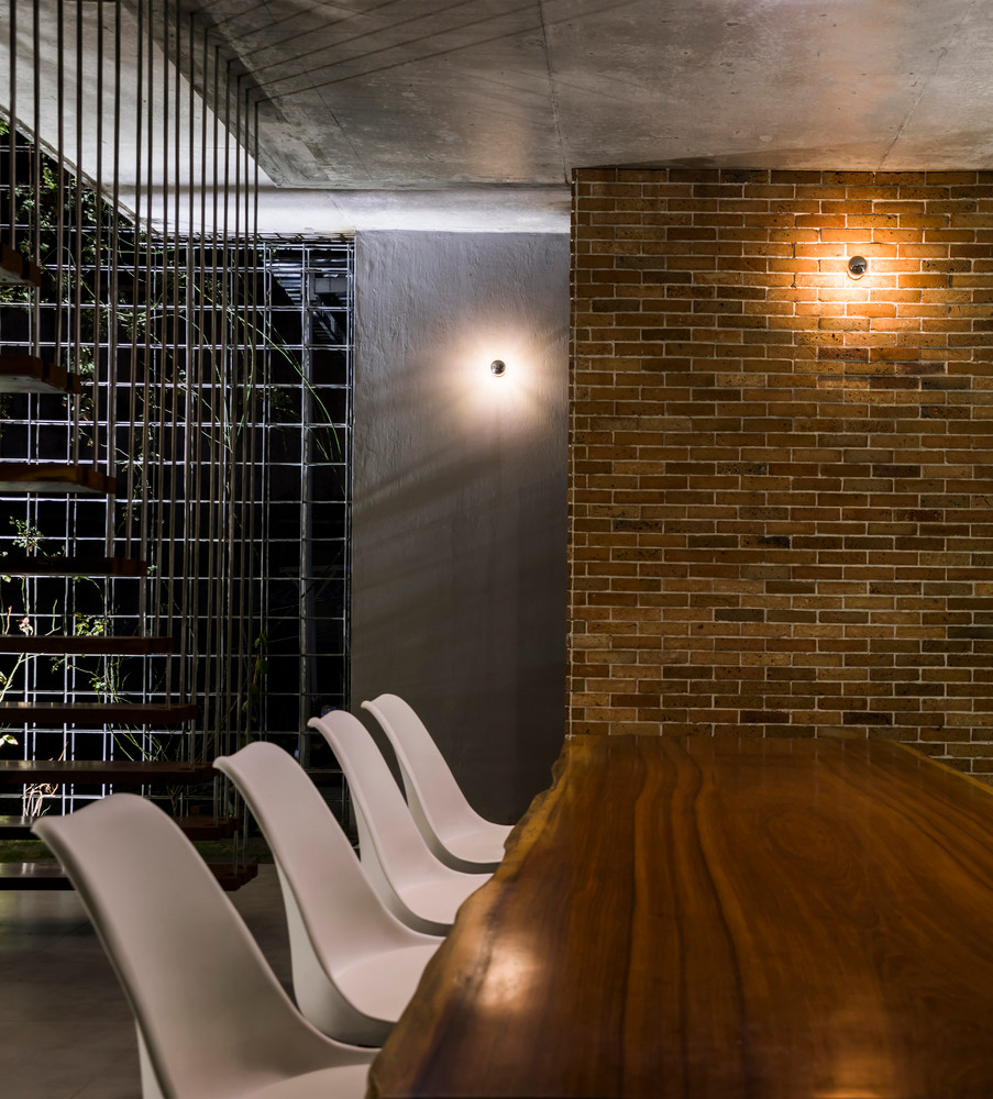 Bàn ăn làm từ tảng gỗ lớn kết hợp cùng ghế nhựa trắng, chân bàn ghế bằng kim loại, tạo cảm giác mới lạ. Ảnh: Hiroyuki Oki