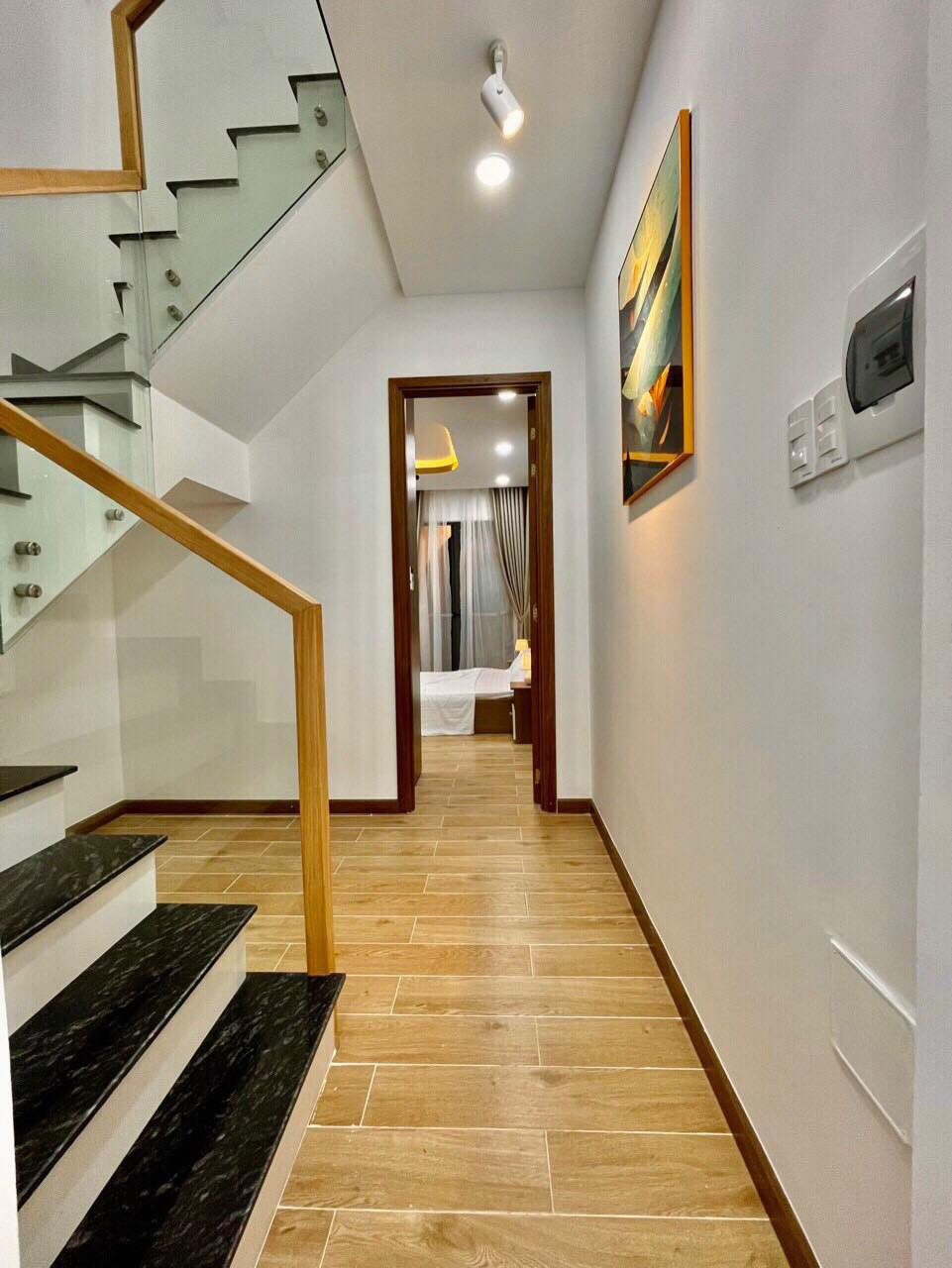 Ngôi nhà có gam màu trắng chủ đạo, lát sàn gỗ sáng màu. Ảnh chụp màn hình