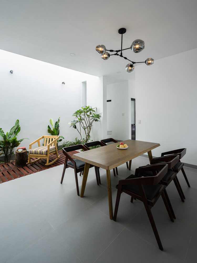 Không gian sống được phân chia bằng cách sử dụng đồ nội thất, kết hợp với khu vườn bên trong và giếng trời lớn, giúp tăng cường cung cấp ánh sáng tự nhiên. Ảnh: Quang Dam