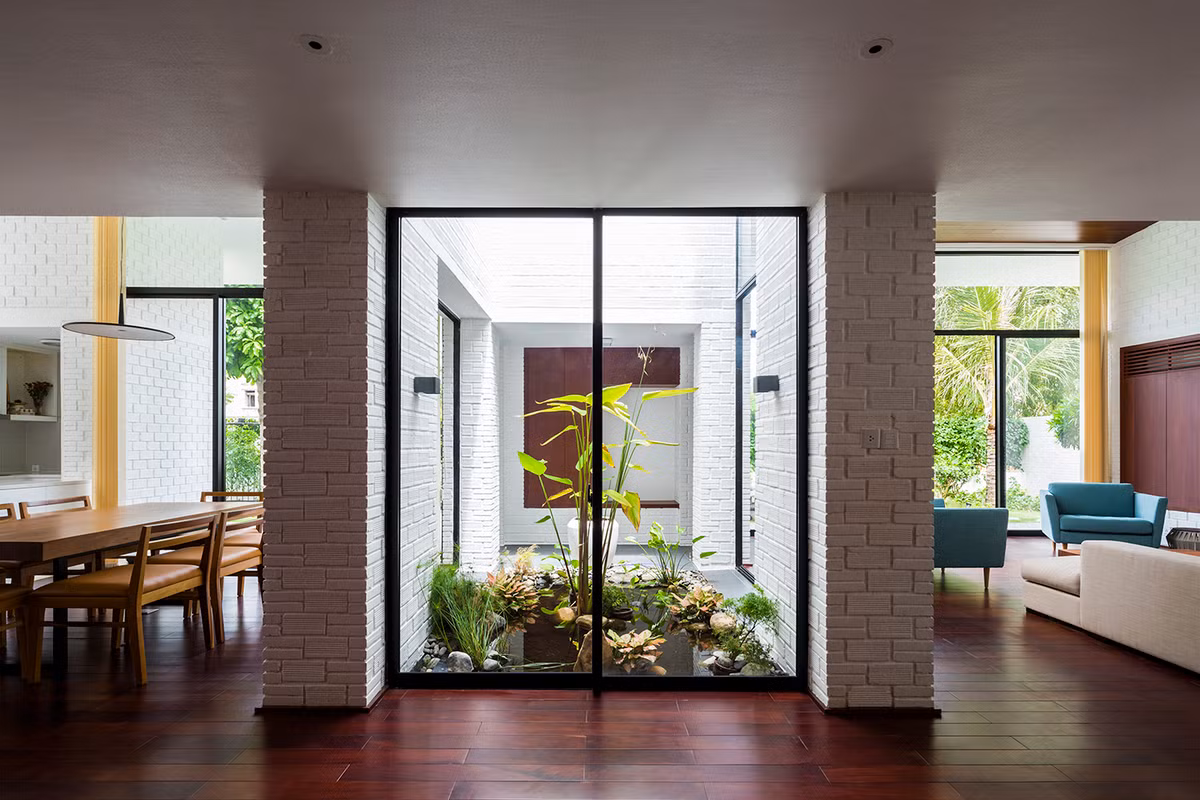 Giữa nhà là khoảng trống để trồng cây xanh, được ngăn cách với khu vực khác bằng tường kính. Ảnh: Hiroyuki Oki
