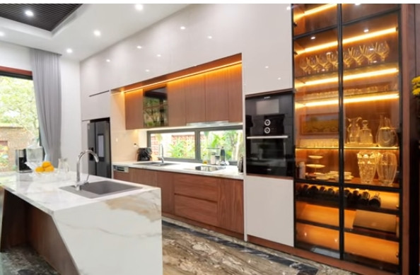 Nhà bếp hiện đại với tủ bếp kịch trần, bàn đảo lớn giữa trung tâm. Ảnh chụp màn hình NhaF