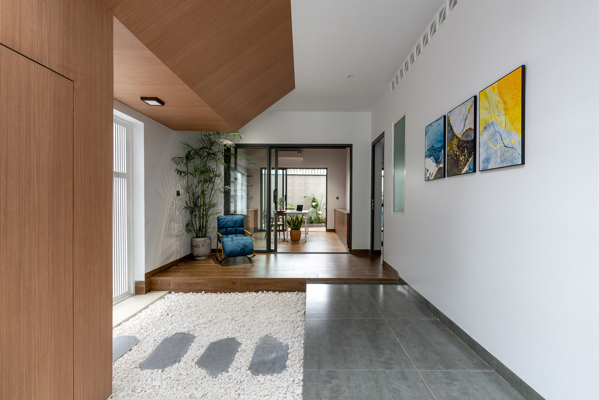 Phía sau bếp là hành lang dẫn ra khu vực phòng ngủ và phòng làm việc ở cuối nhà. Sân trong có chức năng như khoảng đệm, ngăn cách không gian sinh hoạt chung và không gian riêng tư. Ảnh: Lonton Studio