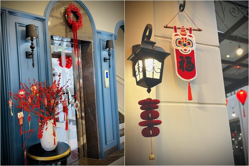 Cửa thang máy được tô điểm bằng vòng nguyệt quế đỏ và bình hoa đào mini rực rỡ. Ảnh: FB Đoàn Di Băng