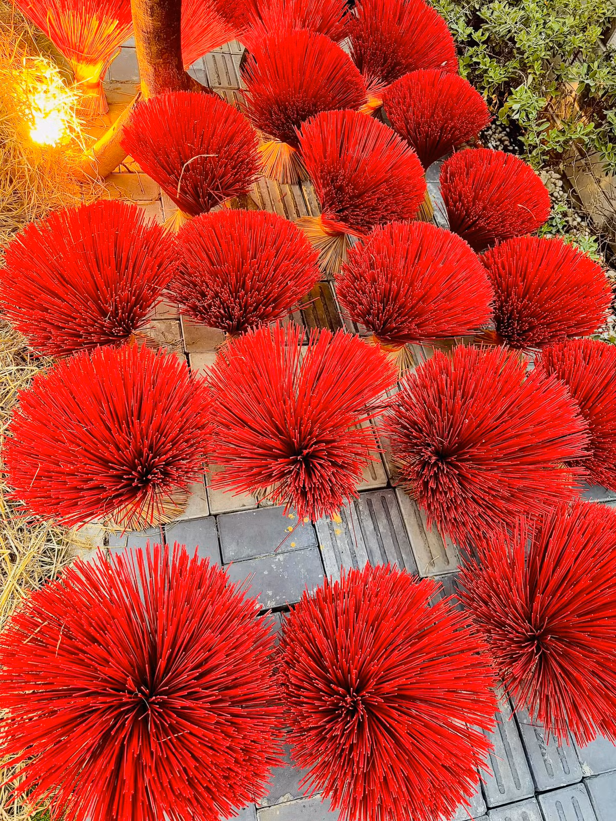 Những bó hương tre đỏ sắp xếp gọn gàng, tạo hình bắt mắt dưới tán cây mai giả. Ảnh: FB Đoàn Di Băng