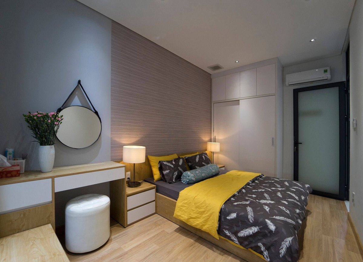 Phòng ngủ trên tầng 2 sử dụng nội thất gỗ và tông màu mang cảm giác ấm cúng. Ảnh: QPS House