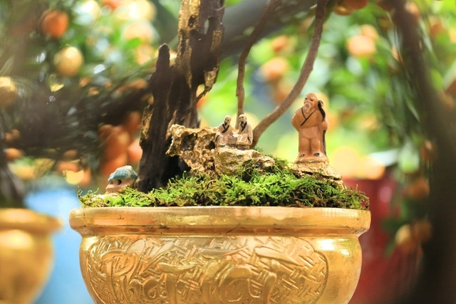 Các nghệ nhân thường phải mất nửa ngày để dát vàng chậu quất. Ảnh: Người đưa tin