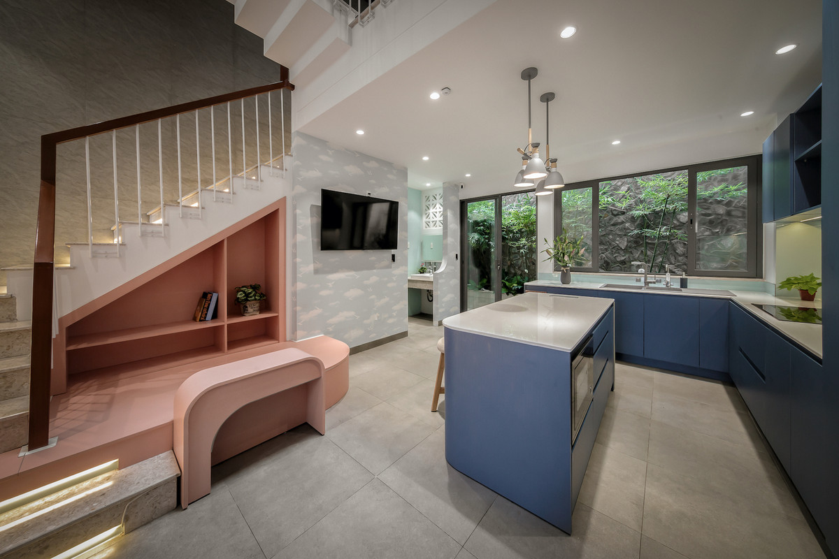 Dưới gầm cầu thang có một không gian vui chơi nhỏ cho các con nhỏ, thuận tiện cho mẹ quan sát con từ trong bếp. Ảnh: Minh Quốc Bùi