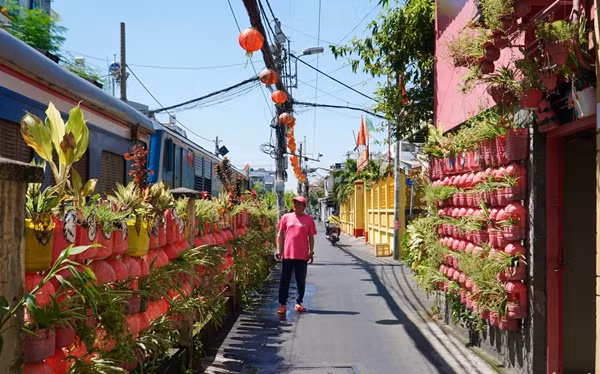 Số hoa cảnh này được trồng trong vỏ chai, lọ nhựa tái chế có màu sơn cùng tông màu với ngôi nhà. Ảnh: Plo