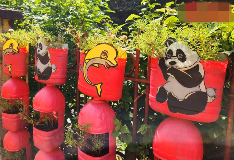 Ông Chánh tìm hình những con vật đáng yêu, sau đó vẽ và tô màu trang trí lên chậu cây. Ảnh: Báo tin tức