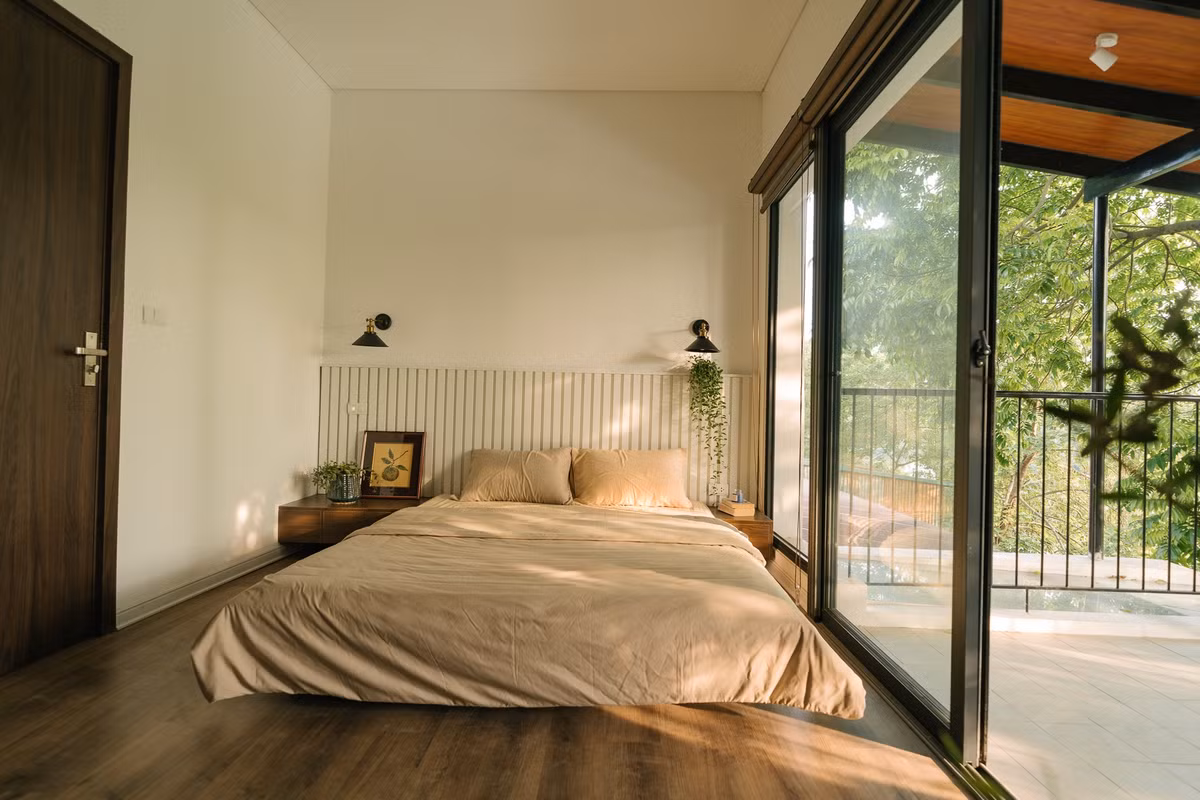 Phòng ngủ ở tầng 2 gam màu ấm cúng, nhẹ nhàng, có ban công rộng rãi. Ảnh: Luke Nguyen Lab