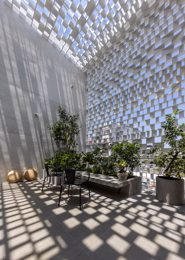 Đặc biệt, ở mặt tiền, tấm sàn lùi vào một khoảng lớn tạo ra một sân vườn ba chiều rộng rãi với khoảng giếng trời liên tục từ tầng một, kết hợp khoảng thông tầng ở phía sau tạo lối đi cho làn gió mát thổi vào nhà. Ảnh: Hiroyuki Oki