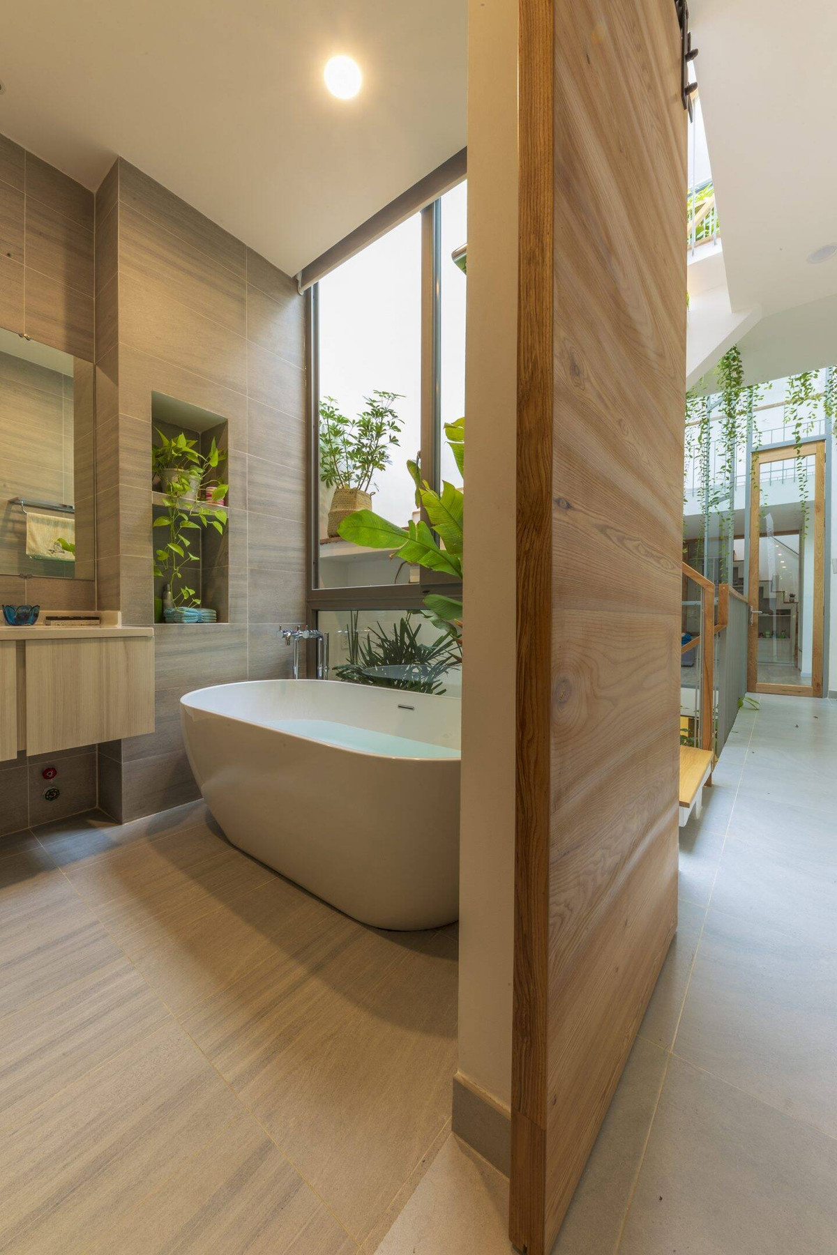 Nhà tắm đặt ngay cạnh giếng trời với hệ cửa trượt giúp tận dụng không gian tối ưu. Ảnh: Thiết Vũ